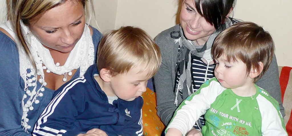 Zwei Frauen und Kinder beim gemeinsamen Lesen.
