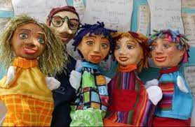 Fünf bunte Handpuppen lächeln in die Kamera.