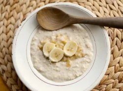 Schüssel mit Haferbrei und Bananenscheiben.