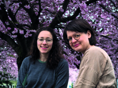 Zwei Frauen sitzen unter einem blühenden Baum